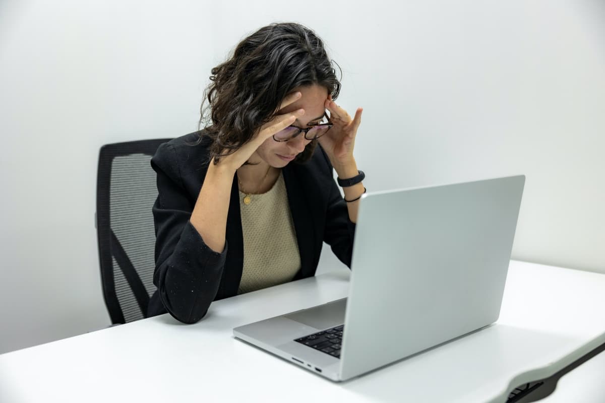 Stressed Woman At Desk With Laptop