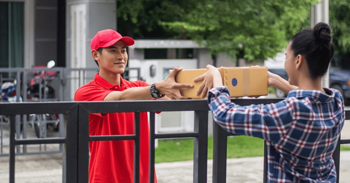 Young man delivering package to customer at home delivery